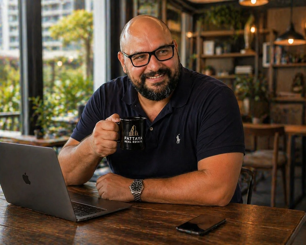 Junger deutschsprachiger Remote-Worker mit Laptop auf der Terrasse eines Condos in Pattaya, Symbolbild für das Destination Thailand Visa (DTV)