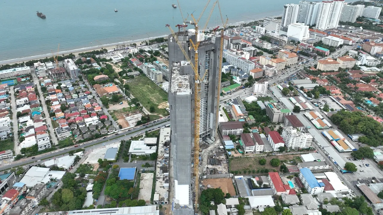 Copacabana Coral Reef Jomtien, construction progress August 2026, the towers within the Jomtien cityscape overlooking the bay