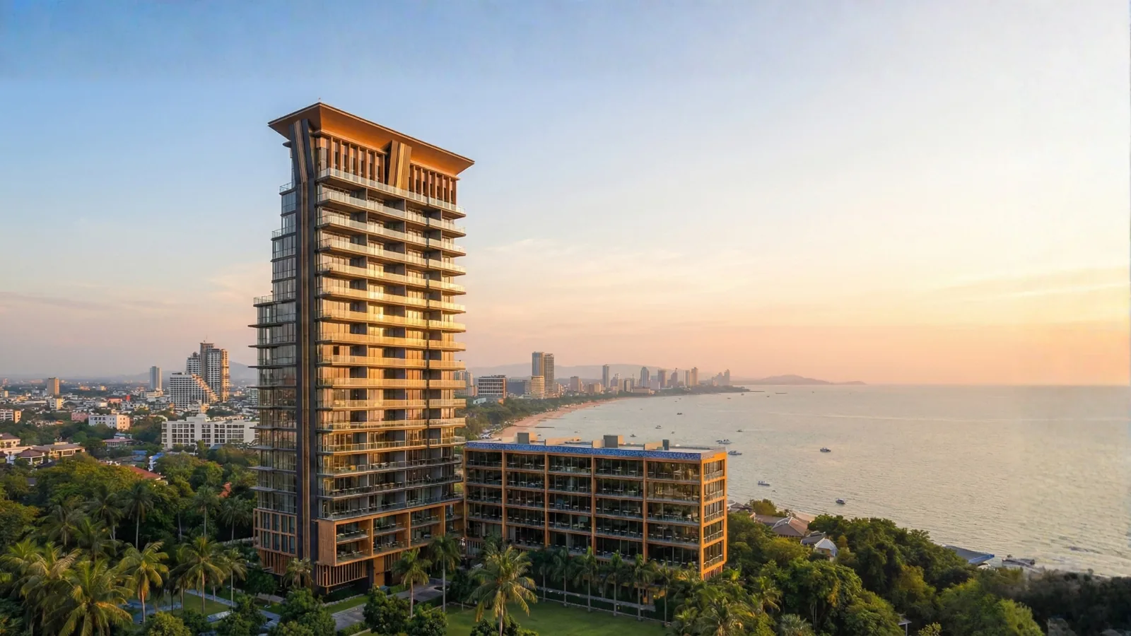 Luftaufnahme des Beachfront-Projekts Sea Sky by Sands in Pratumnak, Pattaya, mit Hochhausturm direkt am Meer und Blick auf die Bucht im Sonnenuntergang