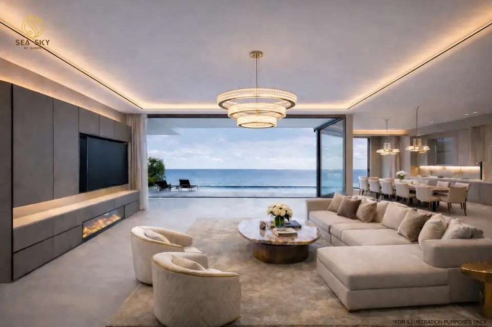Luxuriöses Wohnzimmer einer Residenz im Projekt Sea Sky by Sands in Pattaya mit Eckcouch, Kronleuchter und bodentiefen Fenstern mit Meerblick